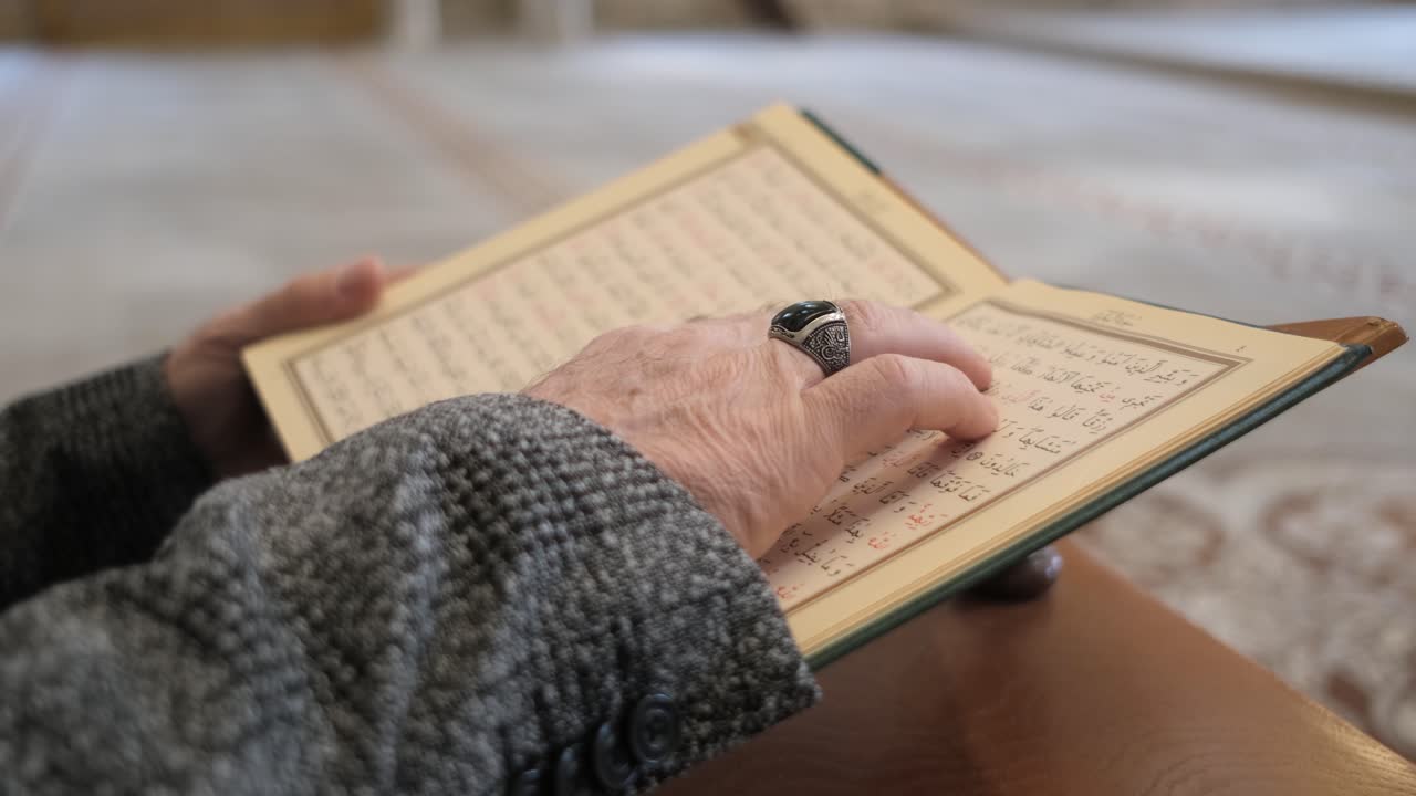 아랍어 꾸란을 들고 있는 사람