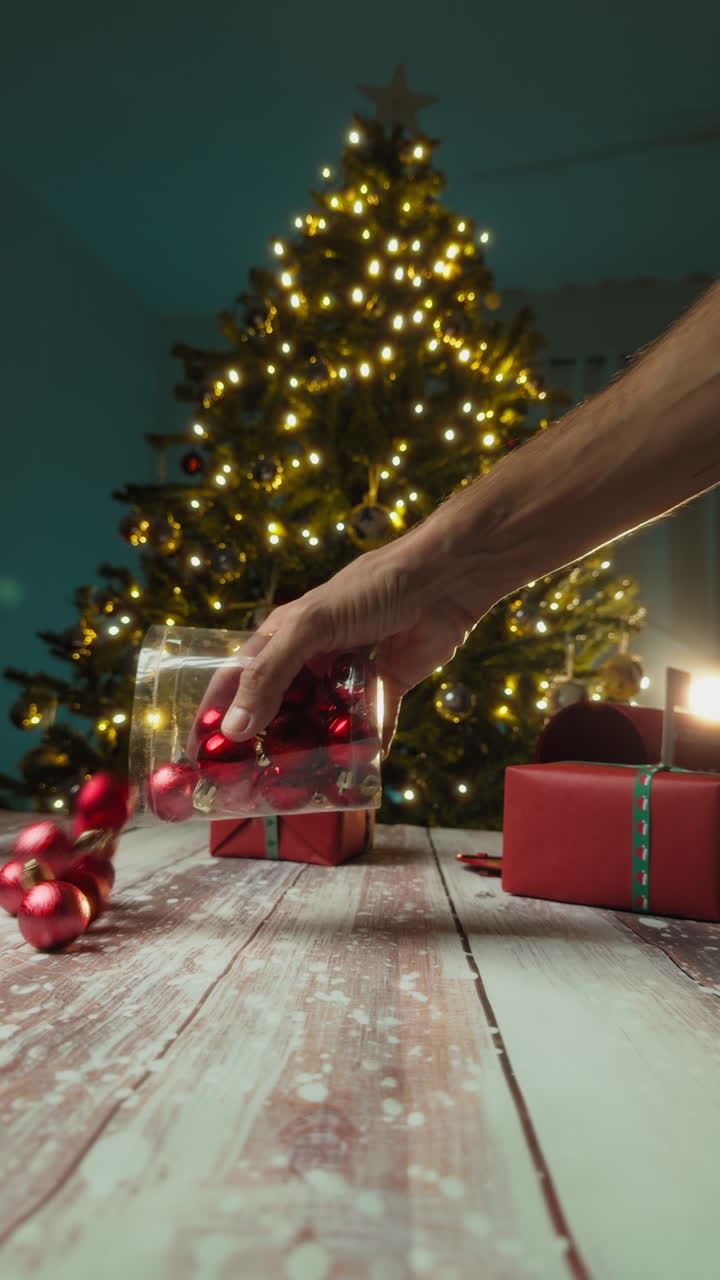 Man hand empties a jar with small red Christmas decorations