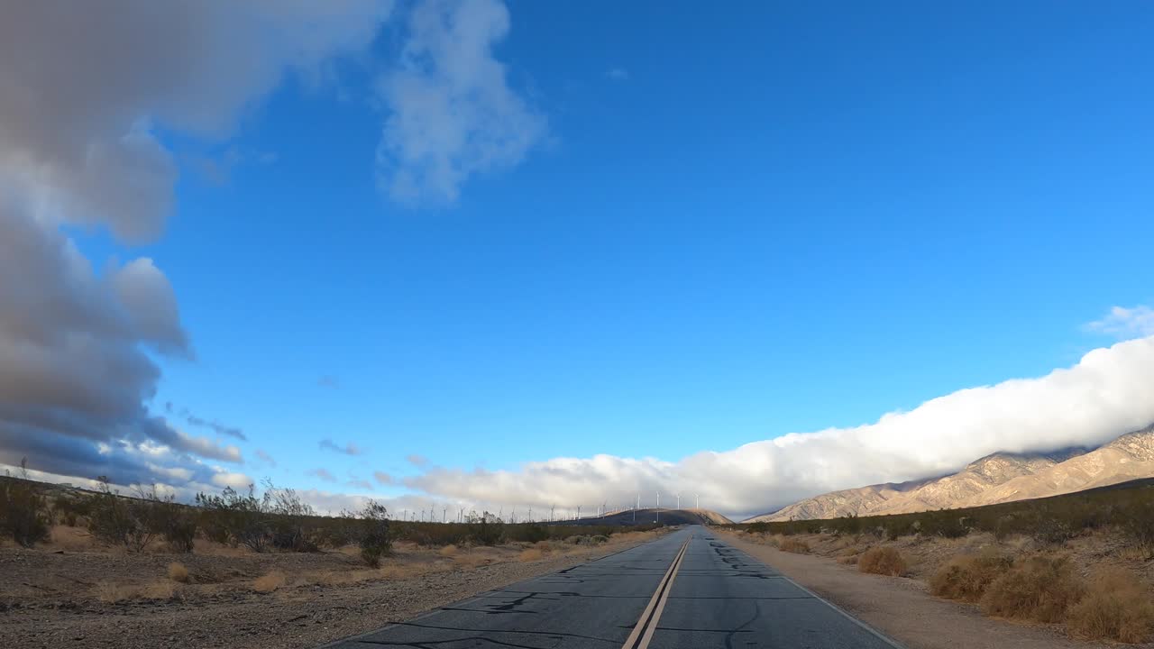 Driving down an empty stretch of road in the middle of the Mojave desert wilderness - point of view