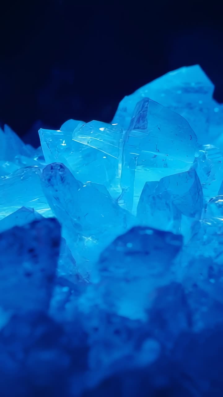 Vertical video: Camera panning across crystal shards at studio, pulsing blue glow revealing facets