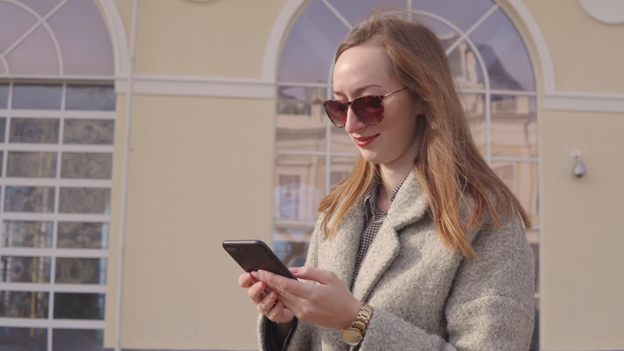Donna che usa il telefono fuori da un edificio