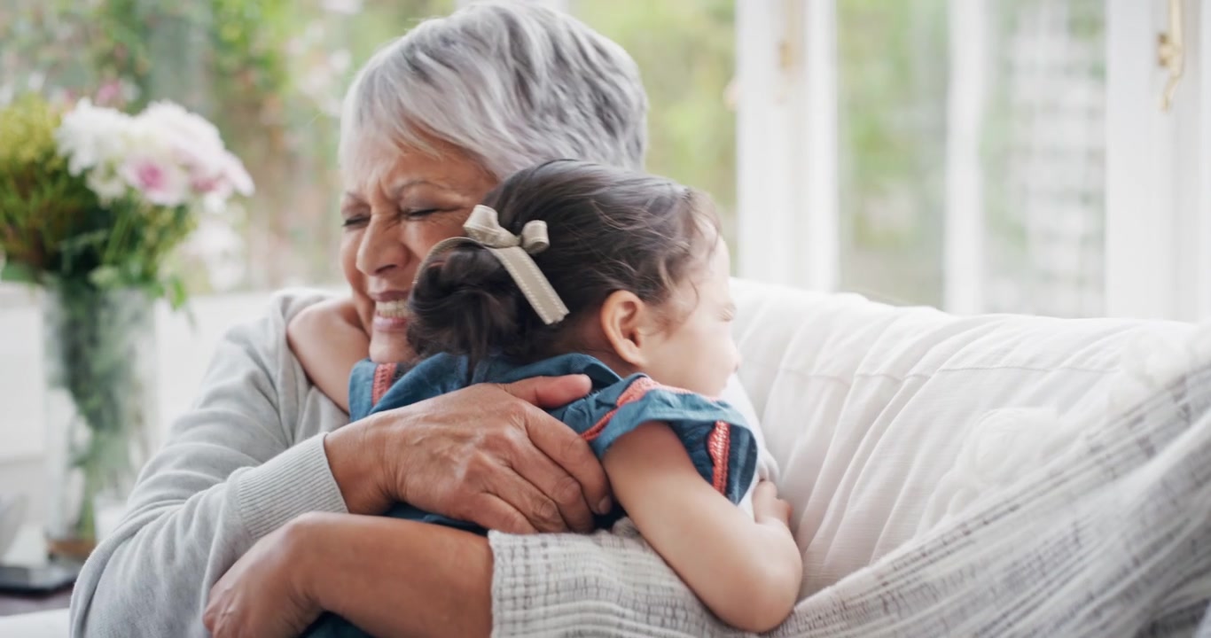 Bambina che corre ad abbracciare la nonna sul divano