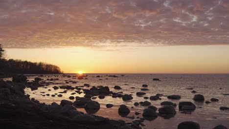 nubes bañadas por el sol con cielo dorado sobre el mar báltico durante la puesta de sol