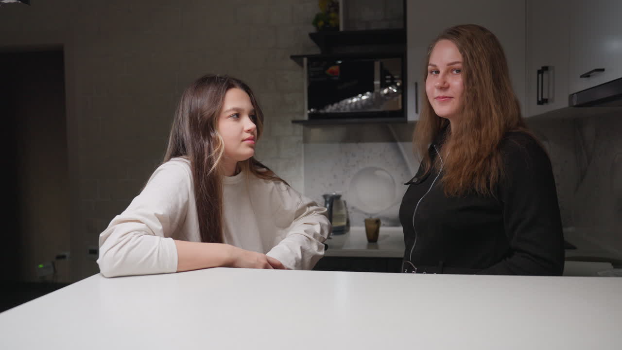 Portrait of picnic partners in kitchen smiling at camera, one giving thumbs up, casual home mood, clean counter foreground, soft daylight on faces, relaxed pose, natural look, warm scene