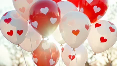 a bunch of red and white balloons with hearts on them