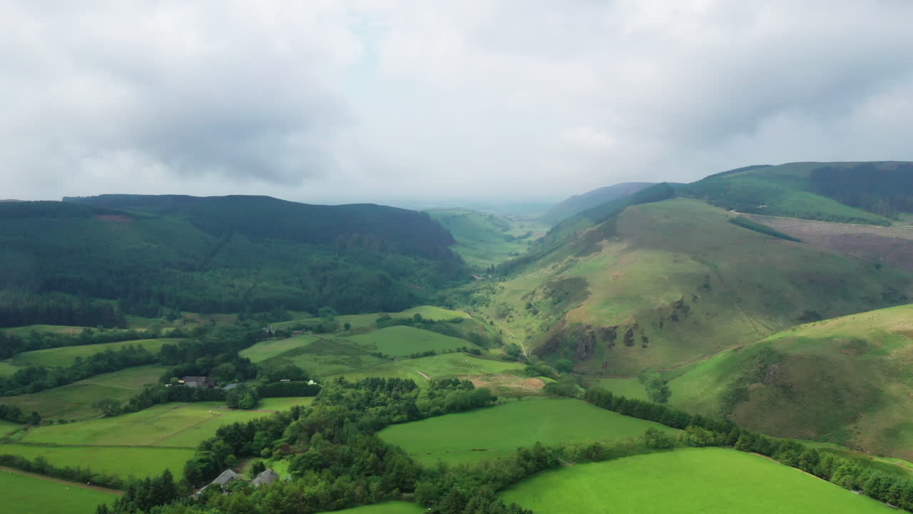 toma panorámica aérea que muestra el campo verde en el distrito inglés de los lagos, un día brillante pero nublado.