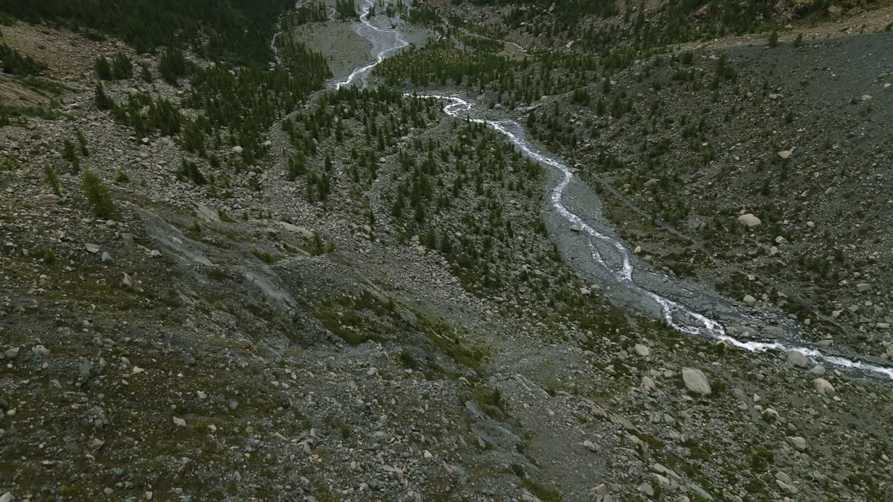 volando sobre una corriente de agua que fluye en el lecho seco del río de montaña de valmalenco en el norte de italia