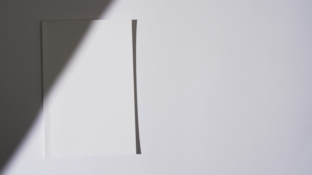 색 배경에 빈  페이지와 복사 공간을 가진 책 위의 그림자의 비디오