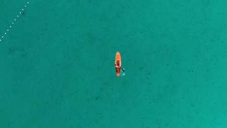 drone overhead view of a stand-up paddle board in a beautiful turquoise sea.