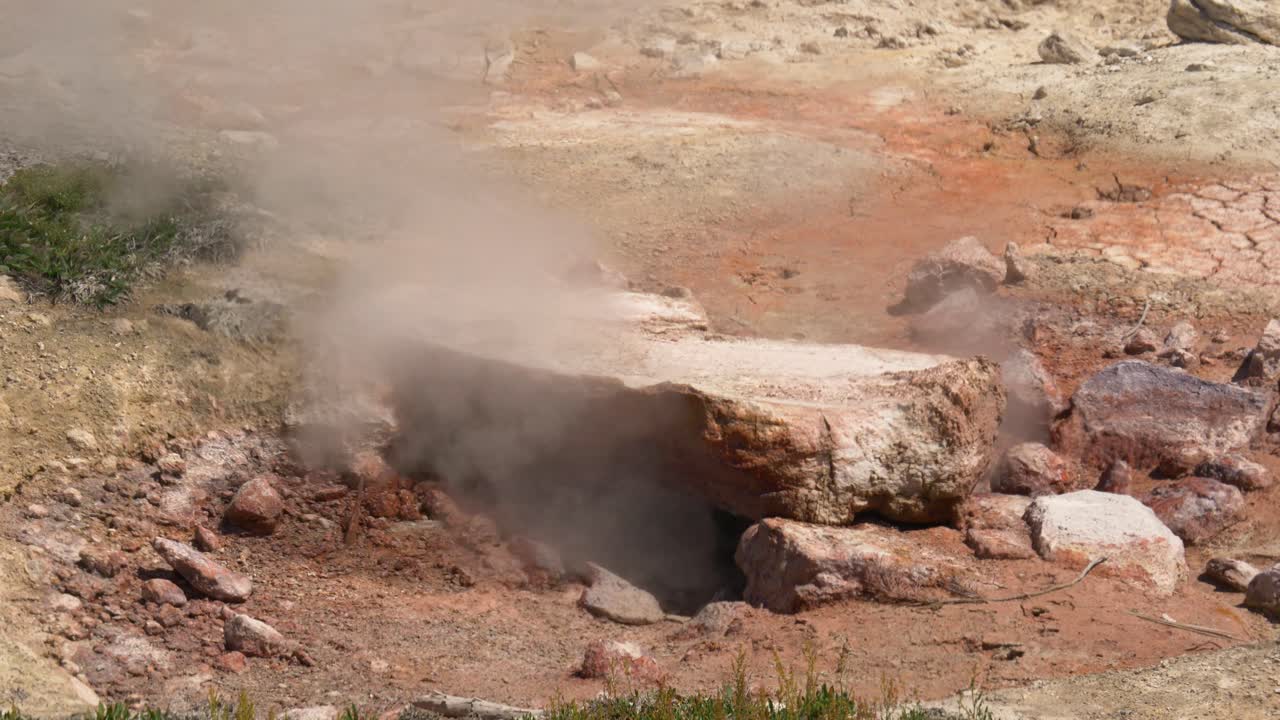 primer plano de vapor saliendo de debajo de la roca en el parque nacional de yellowstone.