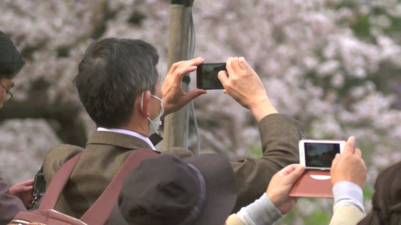 스마트폰으로 사진을 찍는 관광객들