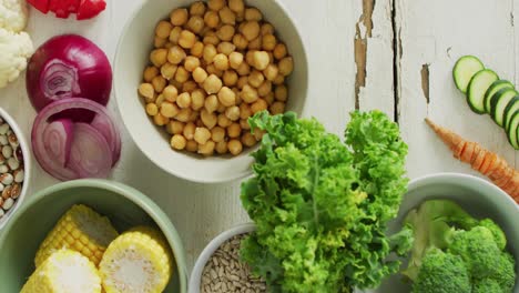 Video-of-bowls-of-fresh-vegetables-over-white-rustic-background