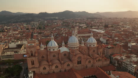 stunning aerial drone shot of the historic center of cuenca, ecuador, highlighting the iconic blue domes of the cathedral of the immaculate conception.