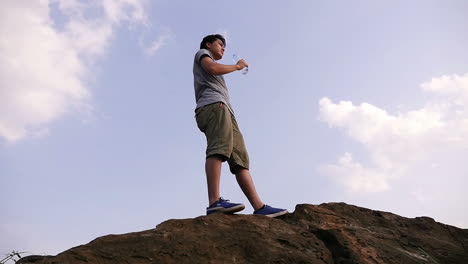 man drinking water on a mountaintop
