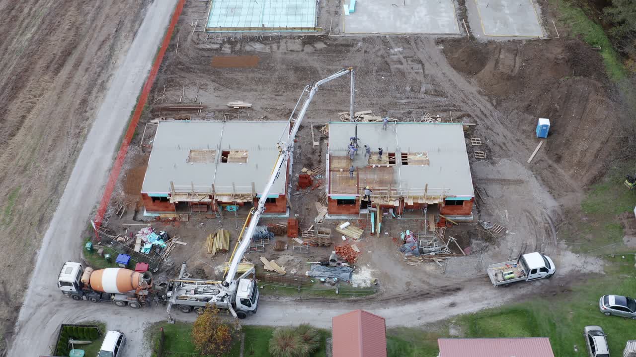 trabajadores de la construcción vierten hormigón y construyen casa familiar
