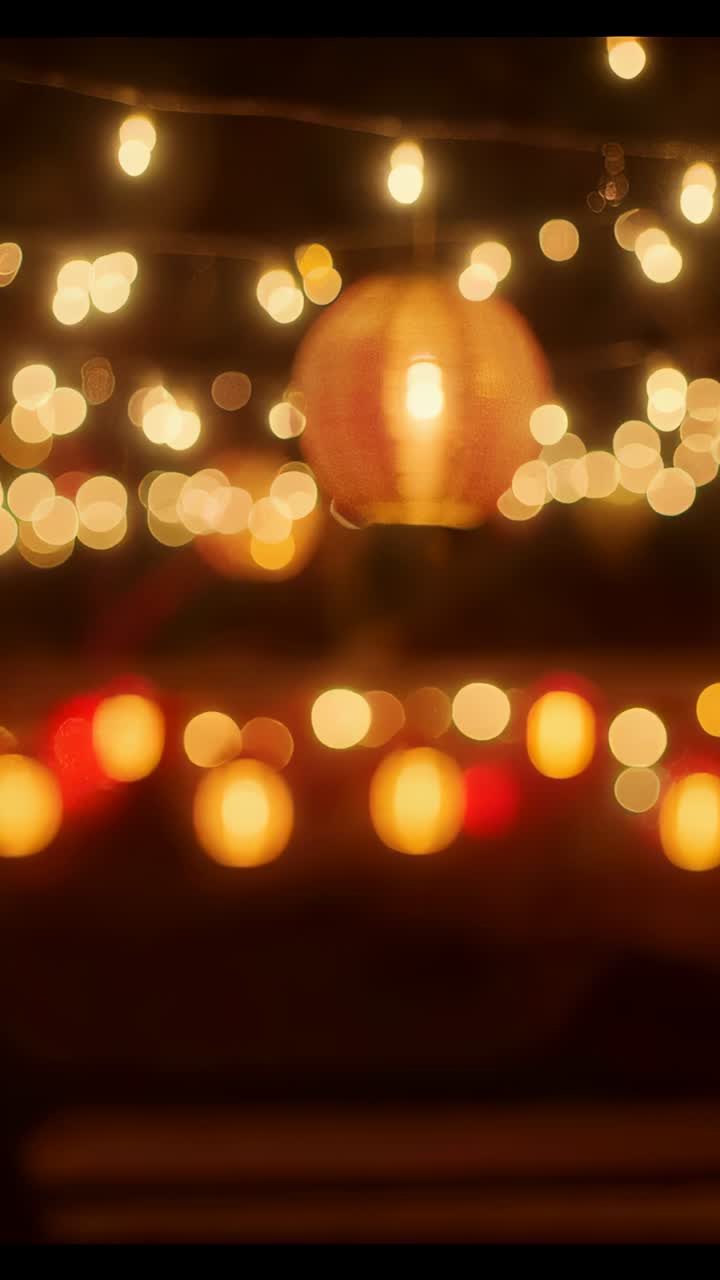 Vertical video: Glowing lanterns drawing adult-child pair entering, admiring paper lantern at night