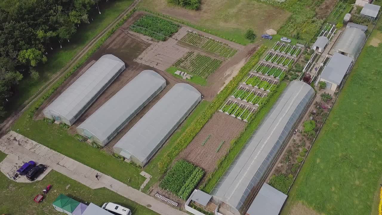 vista aérea de una granja con invernaderos y huertos