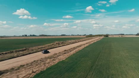 A-jeep-driving-through-a-landscape-in-Argentina-on-a-sunny-day-with-clouds-in-the-sky