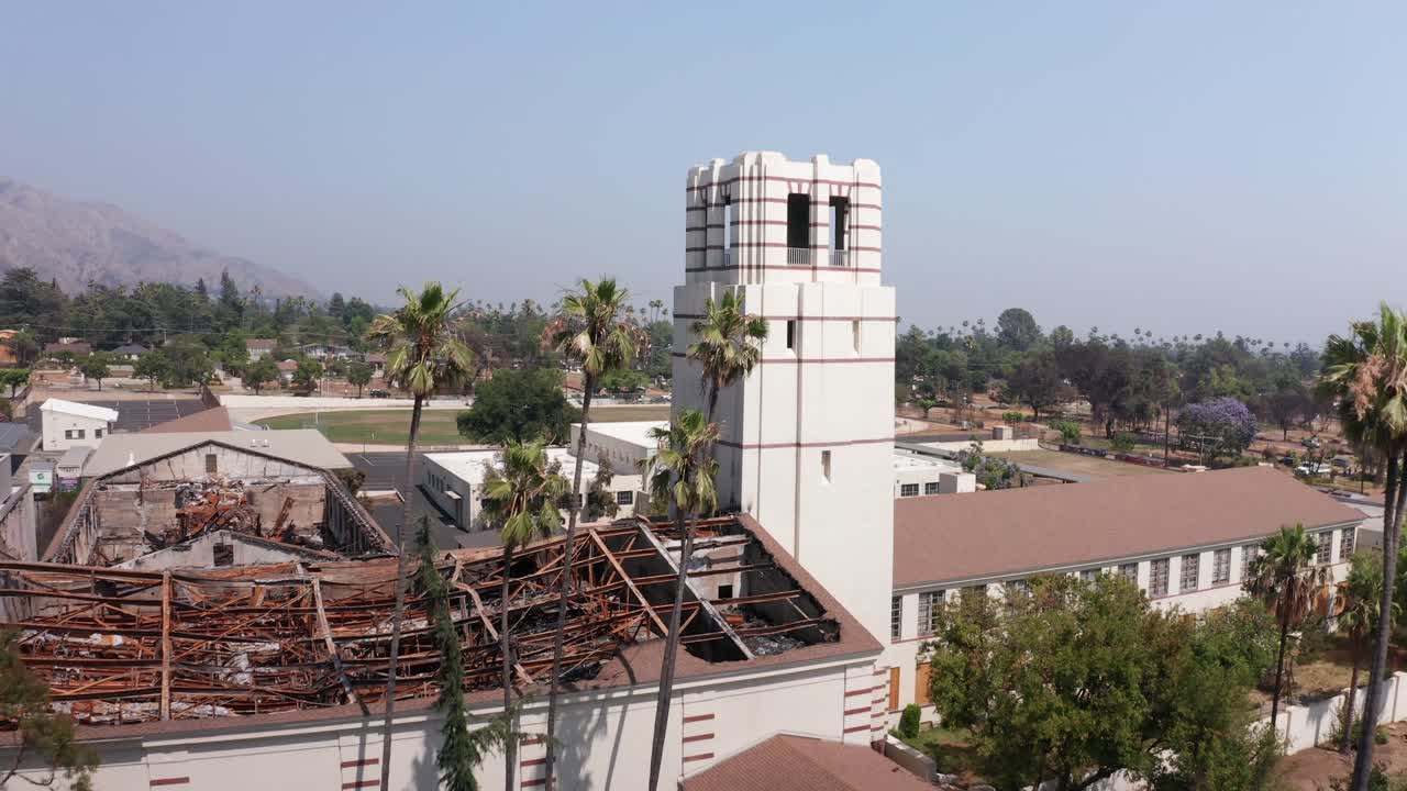 Aerial low rising shot of the burned Eliot Arts Magnet Academy after the Eaton Fire in Altadena, California. 4K