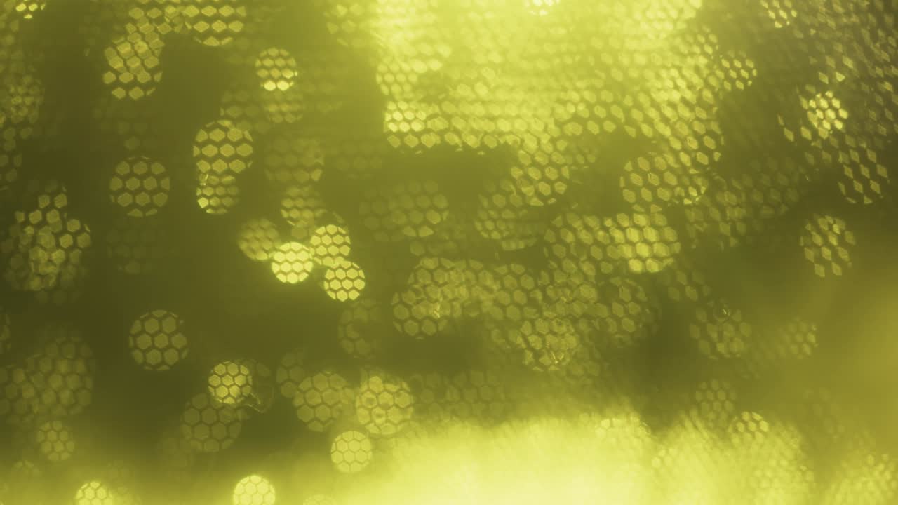 노란색 추상적인 광학적 흐릿한 배경. 움직이는 벌집에 의해 쳐진 광학적 보케.