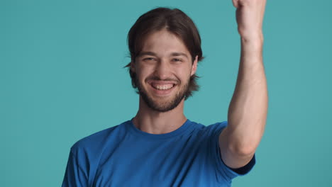 caucasian happy man in front of camera on blue background.