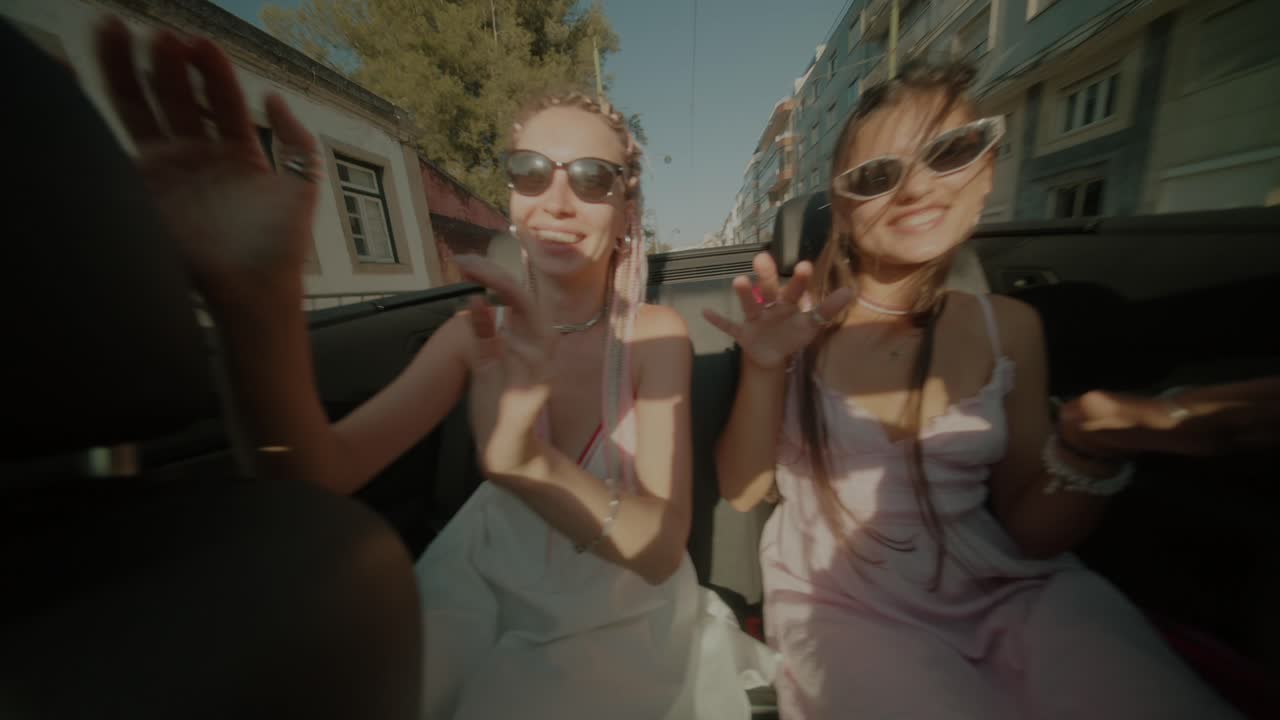 두 명의 여성이 컨버터블에서 도로 여행을 즐기고 있습니다.