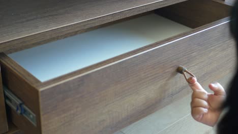 person opening a wooden drawer