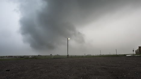 dark textured storm clouds with large hail falling onto the ground