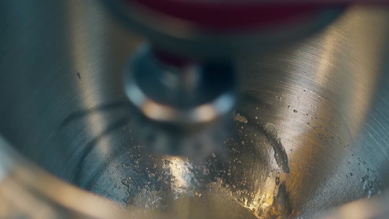 red automatic mixer slowly prepares cake cream with whisk