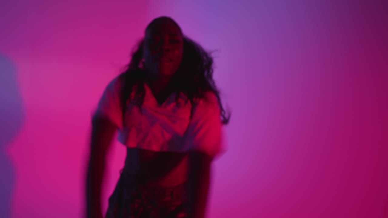 toma de estudio de una joven bailarina bailando contra un fondo iluminado de azul y rosa 7