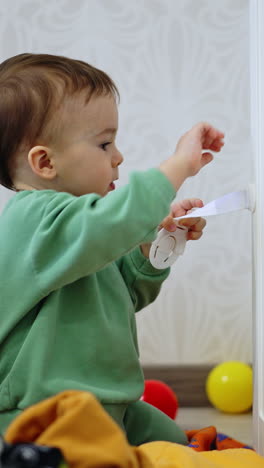curious toddler sitting on the floor at the closet. baby pulls the door open looking inside. vertical video