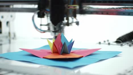 innovative paper crafting: a precision machine creates a stunning 3d papercraft flower from colored sheets in a unique workflow