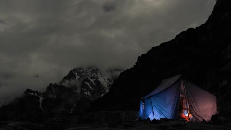 Carpa-Iluminada-En-El-Campamento-Por-La-Noche-Escaladores-Dentro-Y-Fuera