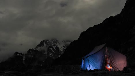 carpa iluminada en el campamento por la noche los escaladores entran y salen