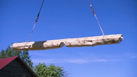 large wooden beam being lifted by crane