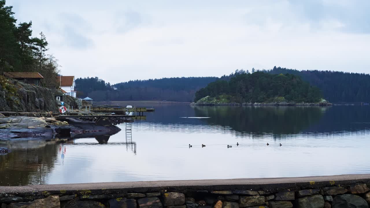 Serene lakeside view in Ljungkile with calm water and overcast skies