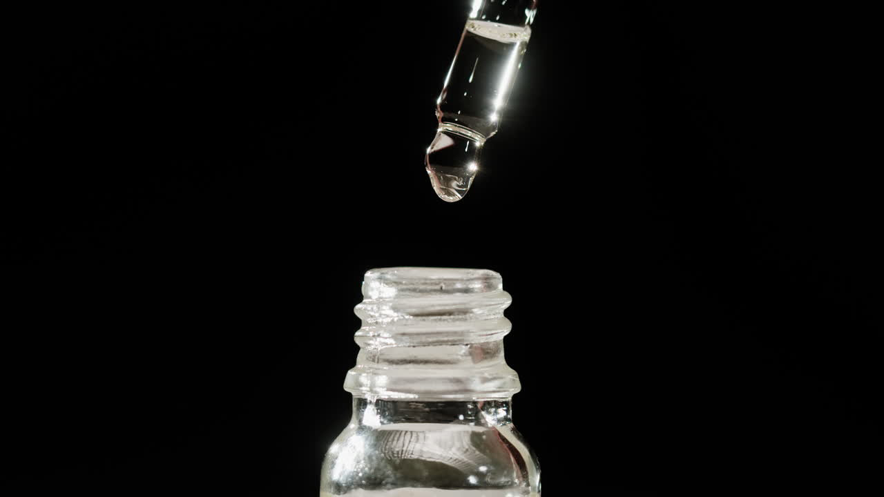 Dropper dispensing liquid into a bottle