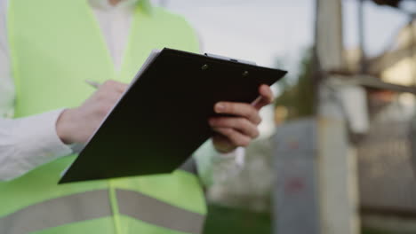 person in a safety vest holding a clipboard