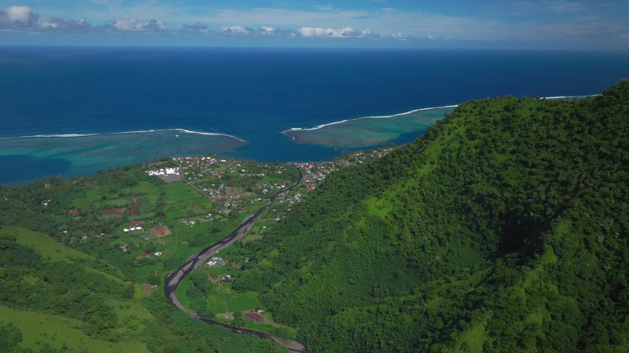 Città di Teahupoo Tahiti Polinesia Francese drone aereo Papeete costa montuosa mattina soleggiata cielo azzurro baia barriera corallina Olimpiadi di Parigi 2024 surf surfista sede nuova torre dei giudici ponte pedonale in basso in avanti.