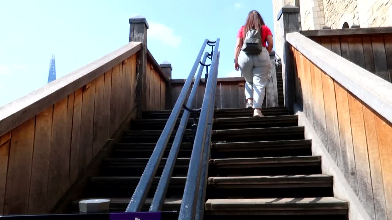 런던 타워의 흰색 탑 계단을 오르는 관광객의 패닝 샷