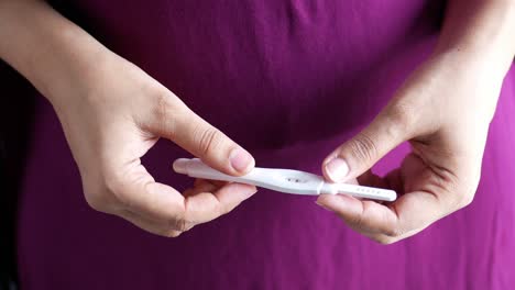 woman holding a pregnancy test