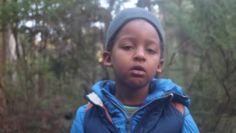 a slow motion shot of a young boy breathing out air in the cold mountain forest of victoria australia