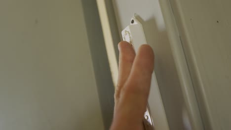 Hand-touches-a-Jewish-Mezuzah-located-in-entrance-of-a-room