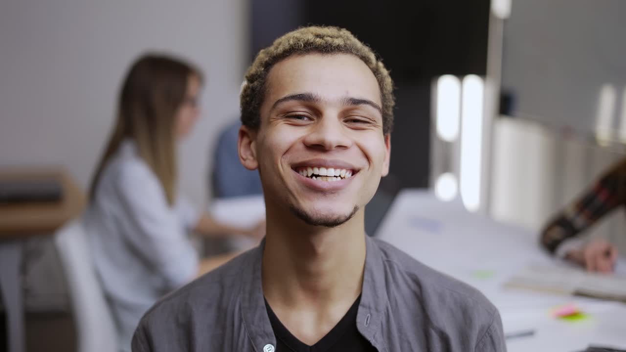 retrato de un hombre de negocios feliz, apuesto hombre de raza mixta de pie en la oficina, mirando a la cámara
