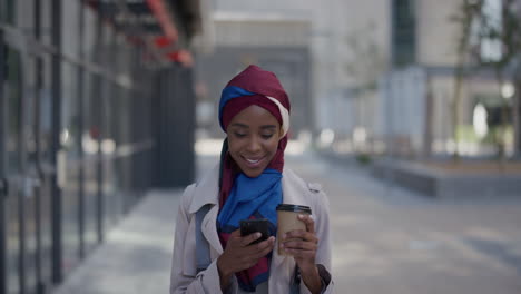 Porträt-Einer-Jungen-Afroamerikanischen-Geschäftsfrau,-Die-Ihr-Smartphone-Benutzt-Und-Sich-In-Der-Mittagspause-Entspannt,-SMS-Schreibt,-Nachrichten-Durchstöbert-Und-E-Mails-Liest-Und-Ein-Hijab-Kopftuch-In-Der-Stadt-Trägt