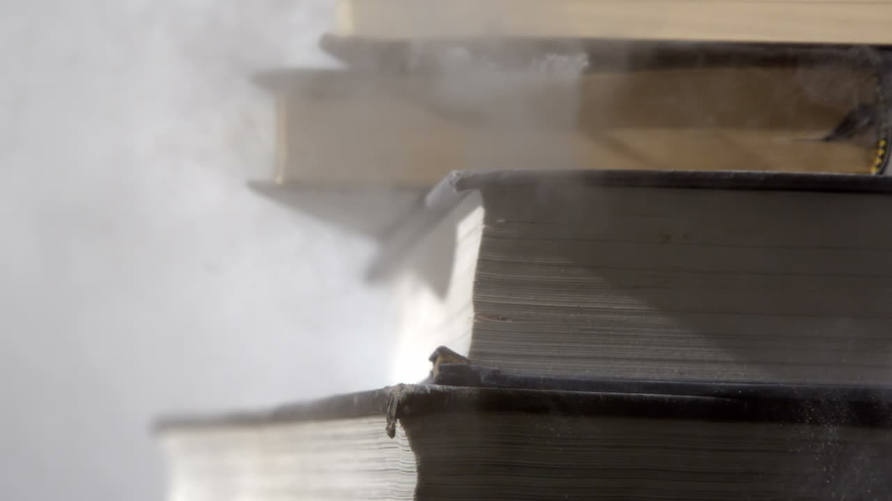 libros negros pesados cayendo sobre una superficie blanca