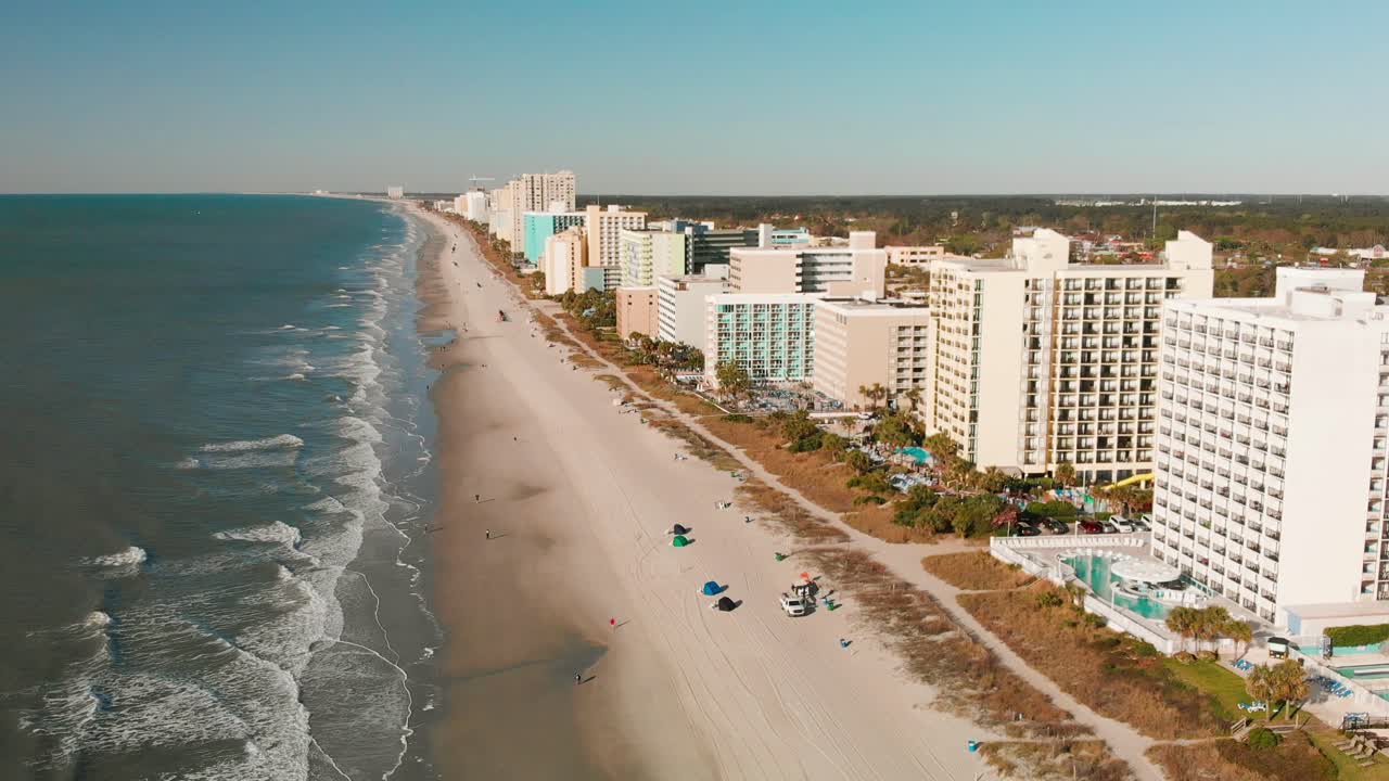 vista aérea de myrtle beach con resorts alineados frente a la playa y olas rompiendo suavemente en la orilla
