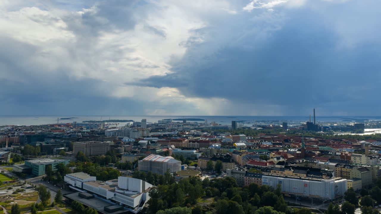 Hyperlapse drone shot of rain clouds behind the sunny cityscape of Helsinki