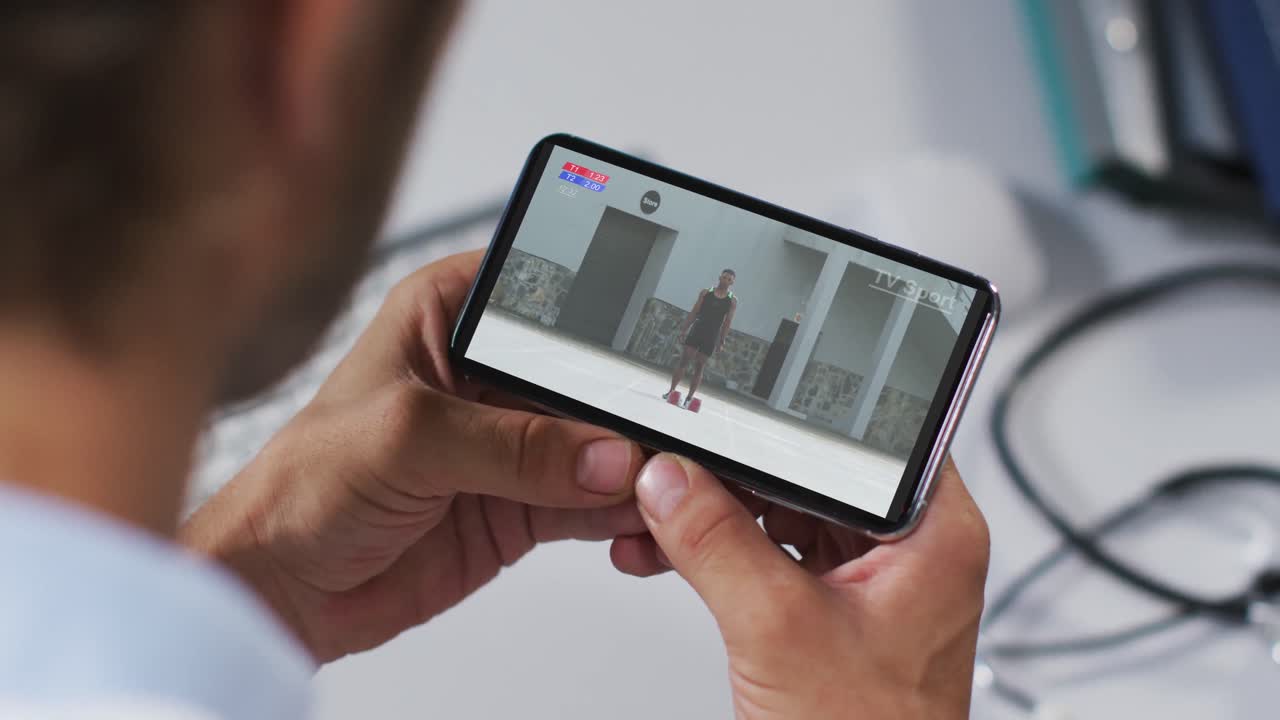 compuesto de un médico masculino viendo un evento de atletismo en un teléfono inteligente