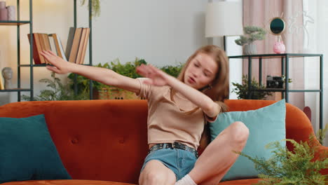 trendy cheerful woman dancing and moving to rhythm making dub dance winner gesture celebrate at home